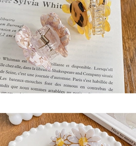 Detail of floral acrylic hair claw clips with metal springs in Korean aesthetic style