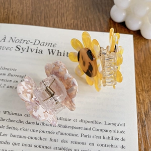 Floral acetate hair claws with leopard center and pink marble finish on book