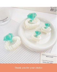 Detailed macro view of ivory hair claws with green crystal accents in two sizes