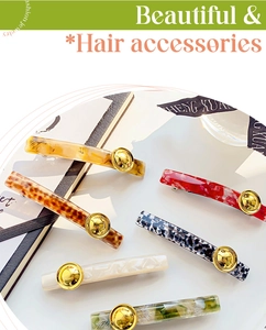 Flat lay of retro acetate hair clips with tortoiseshell and marble patterns on book