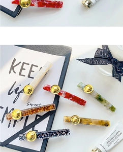 Macro shot of French acetate hair clips with leopard print and gold button detail