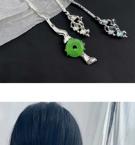 Détail d'épingles à cheveux en argent avec anneau de jade et pierres irisées sur cheveux