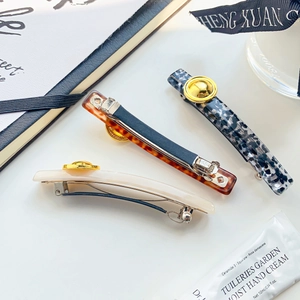 Three vintage French acetate spring hair clips in tortoiseshell and cream with gold buttons