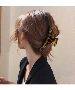 Détail d'une grande pince à cheveux motif léopard écaille sur une coiffure relevée