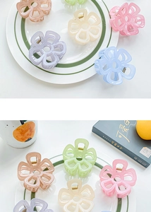 Vue rapprochée de pinces à cheveux fleurs en résine pastel sur une assiette blanche