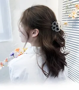 Détail d'une pince à cheveux fleur grise translucide portée pour un style coréen