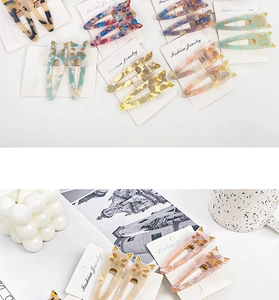 Detailed view of cat-shaped acetate hair clips with marble patterns and gold details
