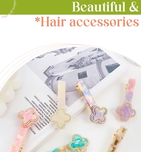 Detail of French style cat hair clips featuring clover motifs and gold handmade engraving
