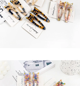Close-up of cat-shaped acetate hair clips in multiple colors on branded display cards