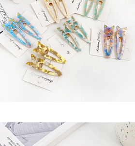 Detailed close-up of cute cat hair clips in marbled acetate finishes on display cards
