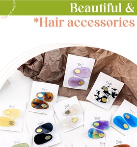 Detailed view of oval acetate hair clips in various marble and tortoiseshell patterns