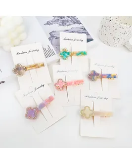 Close-up of colorful clover hair clips with sparkling rhinestones and marbled acetate texture