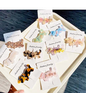 Detail of dachshund-shaped acetate hair clips with tortoise and marble textures