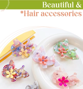 Détail de cinq barrettes à cheveux en acétate forme bouledogue avec fleurs et strass