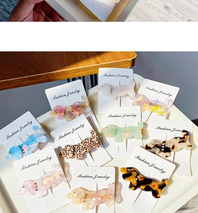 Detail view of acetate dachshund hair clips with leopard print and crystal accents