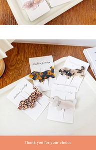Detail of four acetate dachshund hair clips with rhinestones in marble and tortoiseshell patterns