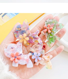 Détail de barrettes à cheveux en acétate en forme de chien avec fleurs et cristaux