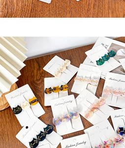 Three cat-shaped resin hair clips in multiple colors displayed on a white card