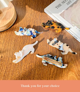 Detailed close-up of 5-piece cat shaped acetate hair clips on a textured wooden table