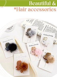 Nahaufnahme der Plüsch-Hasen-Haarspangen mit weichen Pompons und goldenen Nieten