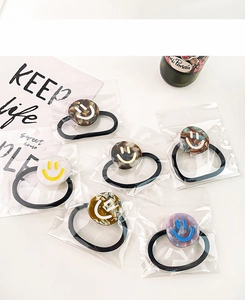 Detail view of high elasticity hair ties with marble-patterned smiley face resin charms