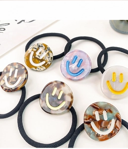 Close-up of acetic acid hair ties with marble texture and minimalist smiley face designs