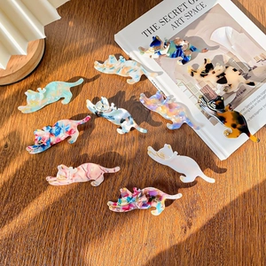 Chic acetate cat hair clips in various patterns on a warm wooden background