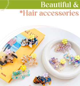 Dettaglio dei fermagli per capelli a forma di gatto in acetato con perle e piccoli fiori