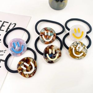 Set of 6 elastic hair ties featuring marble textured smile face acetate charms