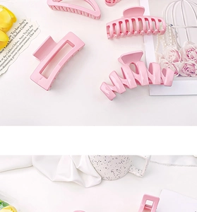 Flatlay de pinces à cheveux en résine rose bonbon aux diverses formes géométriques