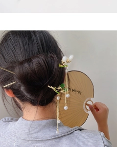 Detail of golden hair stick with pearl tassels and green leaves for Hanfu hairstyle