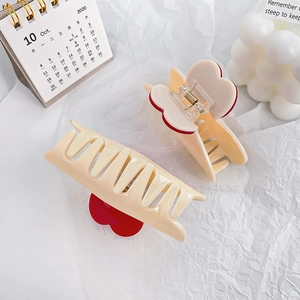 Lot de pinces à cheveux crème avec détails cœurs rouges sur fond blanc froissé