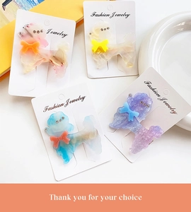 Macro view of acetate poodle hair clips with sparkling rhinestones and colorful bowties