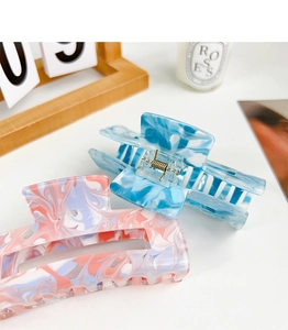 Detail of large marble texture hair claws in blue and pink ink wash patterns