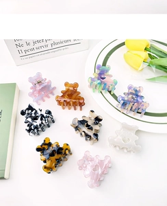Diverses pinces à cheveux ours en acétate avec motifs marbre et écaille sur un plateau