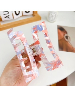 Close-up of marble pattern acrylic hair claw clip with sturdy metal spring detail