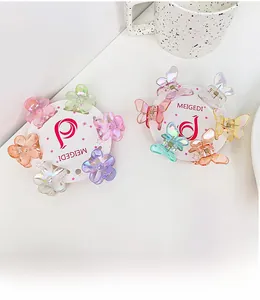 Détail de mini pinces à cheveux irisées en forme de fleur et papillon sur carte blanche