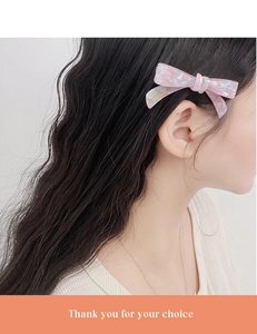 Pink marble acetate bow hair clip with gold France engraving shown on model hair