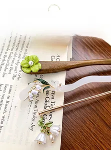 Detail view of Chinese vintage hair pins with green flowers and lily of the valley charms