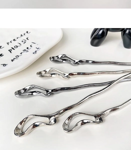 Macro detail of irregular fluid metal hairpins in silver and gunmetal finish