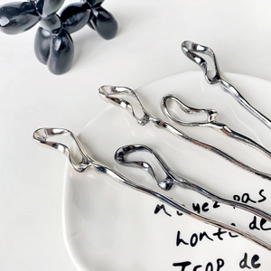 Set of four liquid metal hair sticks with abstract irregular curves in silver finish