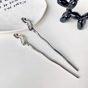 Minimalist silver metal hair sticks with modern irregular hollow design on white plate