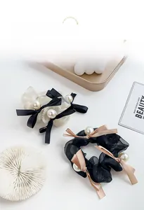 Detailed view of elegant organza hair scrunchies with satin bows and faux pearl embellishments