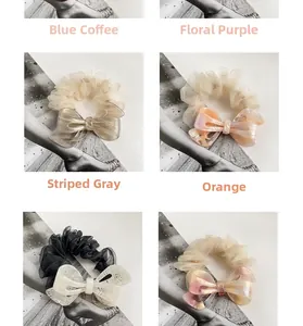 Detailed view of four acetate bow hair scrunchies in gray, orange, blue, and purple colors