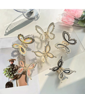 Detailed arrangement of six crystal butterfly hair claws on a stylish textured display