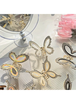 Detail of golden butterfly hair claw with shimmering rhinestones and opal-like wings