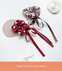 Détail de chouchous en satin avec perles blanches en bordeaux et couleur champagne