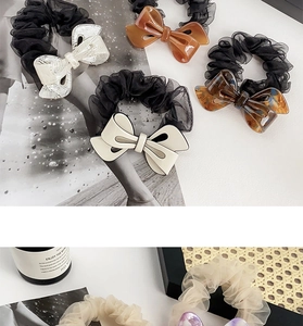 Close-up of elegant bow scrunchies in organza with acrylic marble and amber details