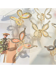 Detailed macro view of butterfly hair claws with gold frames and shimmering rhinestones