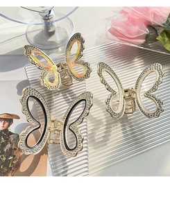 Detailed close-up of golden butterfly hair claws with rhinestones in multiple colors